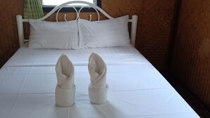 A neatly made bed with white linens and pillows, a white metal headboard, and a window with curtains. - Save Bungalows (Koh Tao)