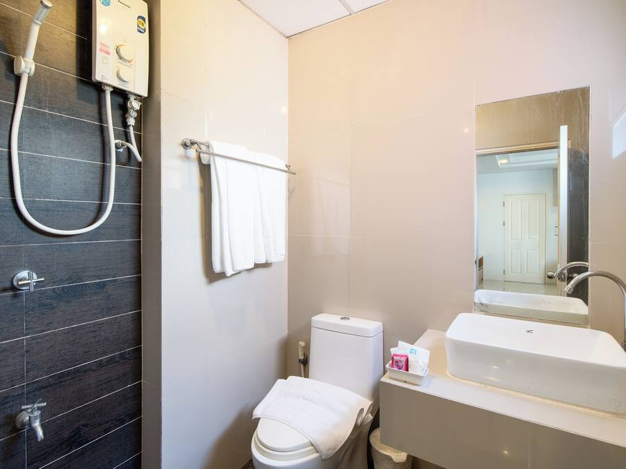 A bathroom with a shower, toilet, sink, and a mirror.