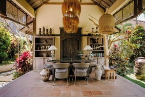 A traditional interior with a dining area, wooden furniture, and a variety of decorative items.