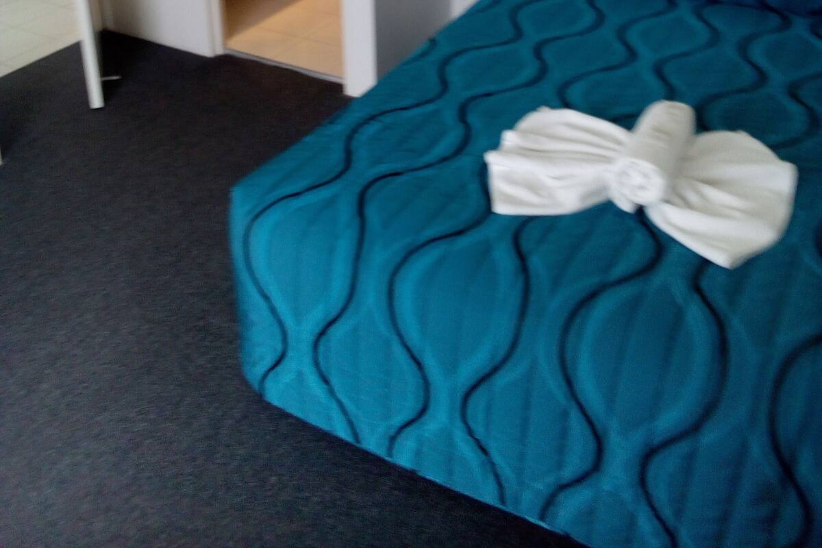 Una habitación de hotel con cama, baño y escritorio.