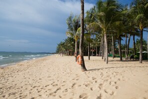 Pantai pribadi, pasir putih, payung pantai, dan handuk pantai