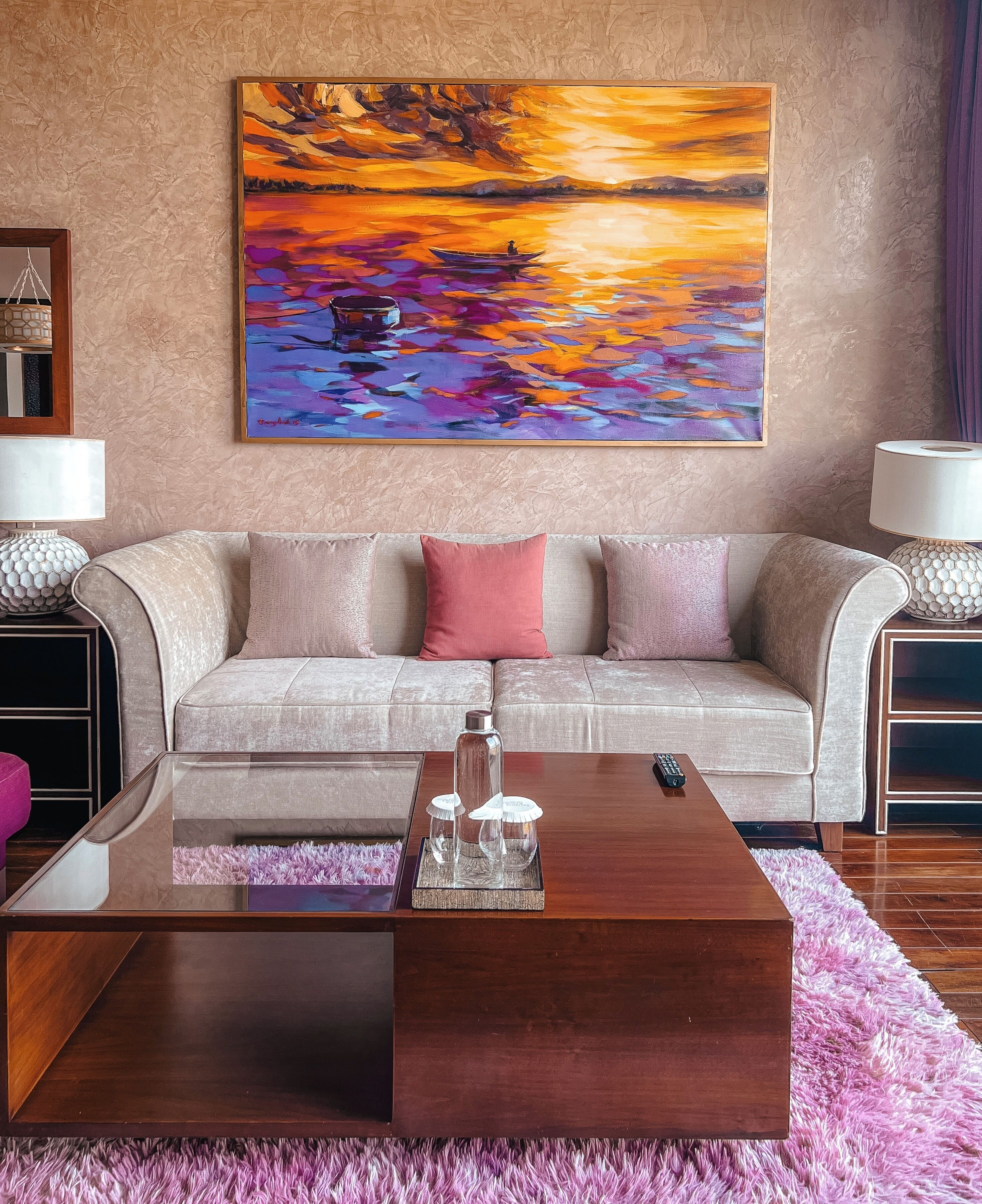 A living room with a sofa, coffee table, and artwork on the wall.