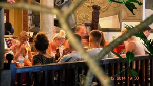 A group of people seated at a bar with a decorative wall in the background. - Time N Tide Beach Resort (Hikkaduwa)