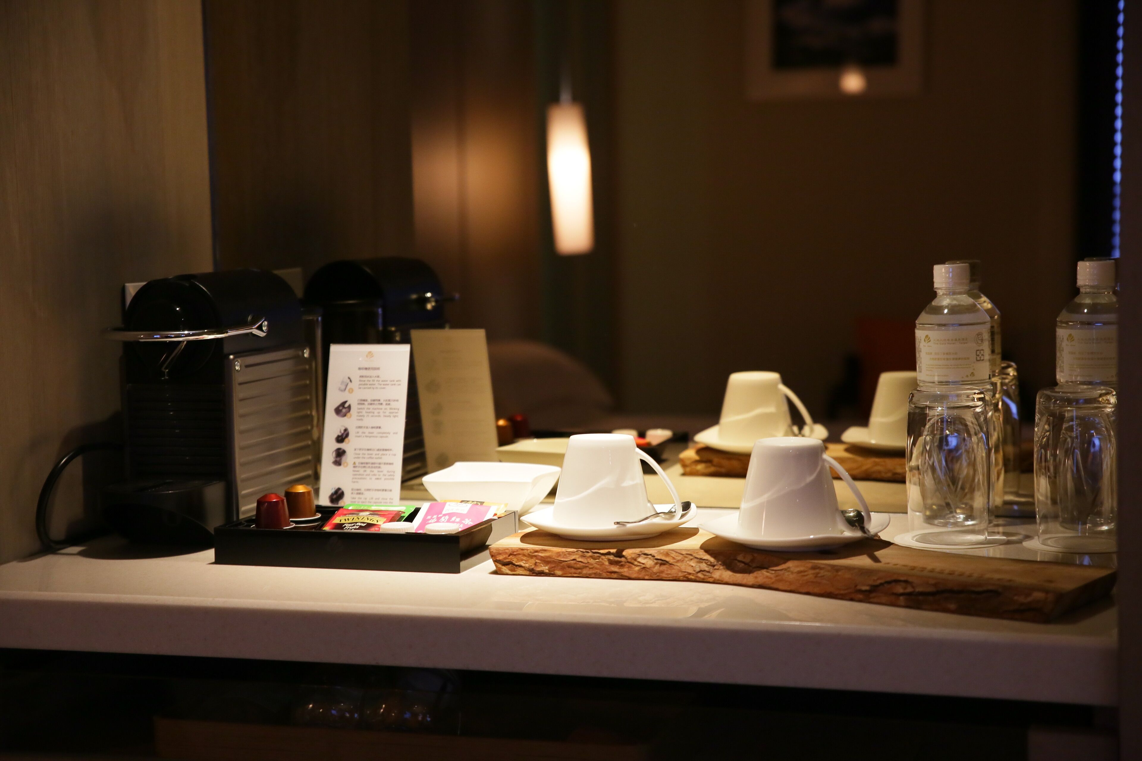 Une table dressée pour le petit-déjeuner, avec des machines à café, des tasses et des bouteilles d’eau.