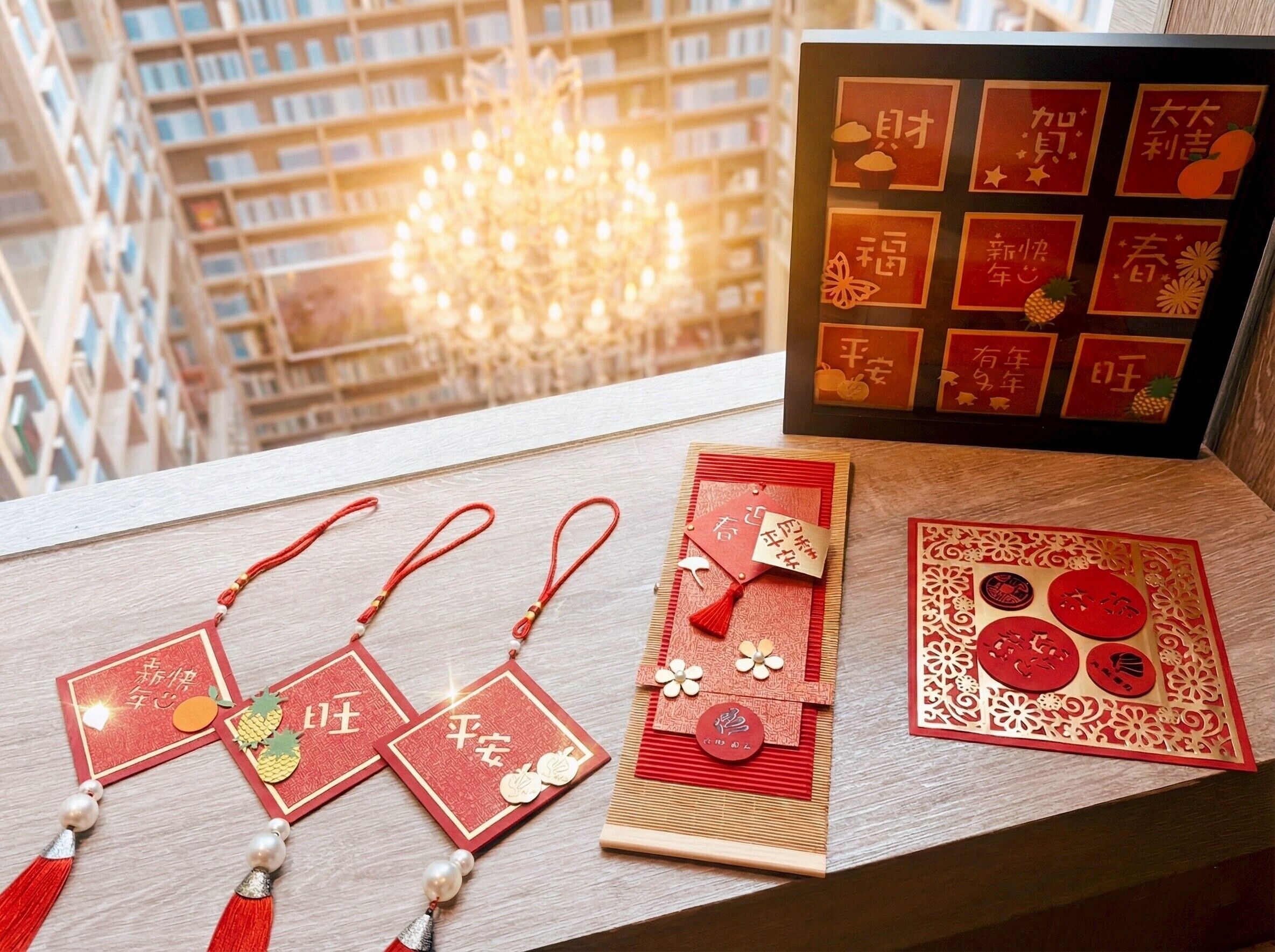 A collection of red Chinese New Year decorations on a windowsill, including paper cuttings and ornaments.
