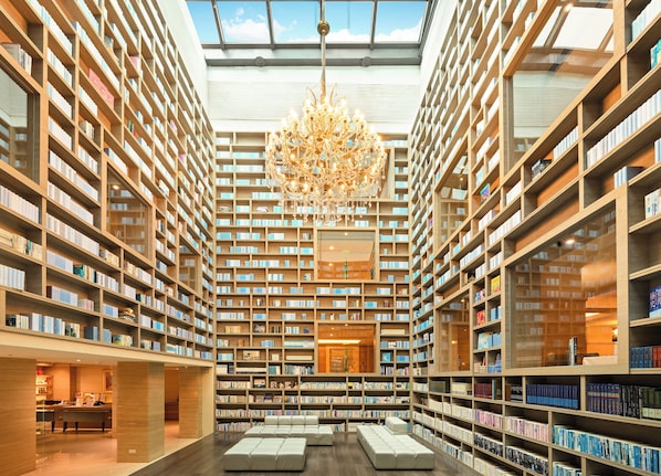A spacious library with high ceilings, a central chandelier, and bookshelves on all sides. - The Gaia Hotel Taipei (Taipei)