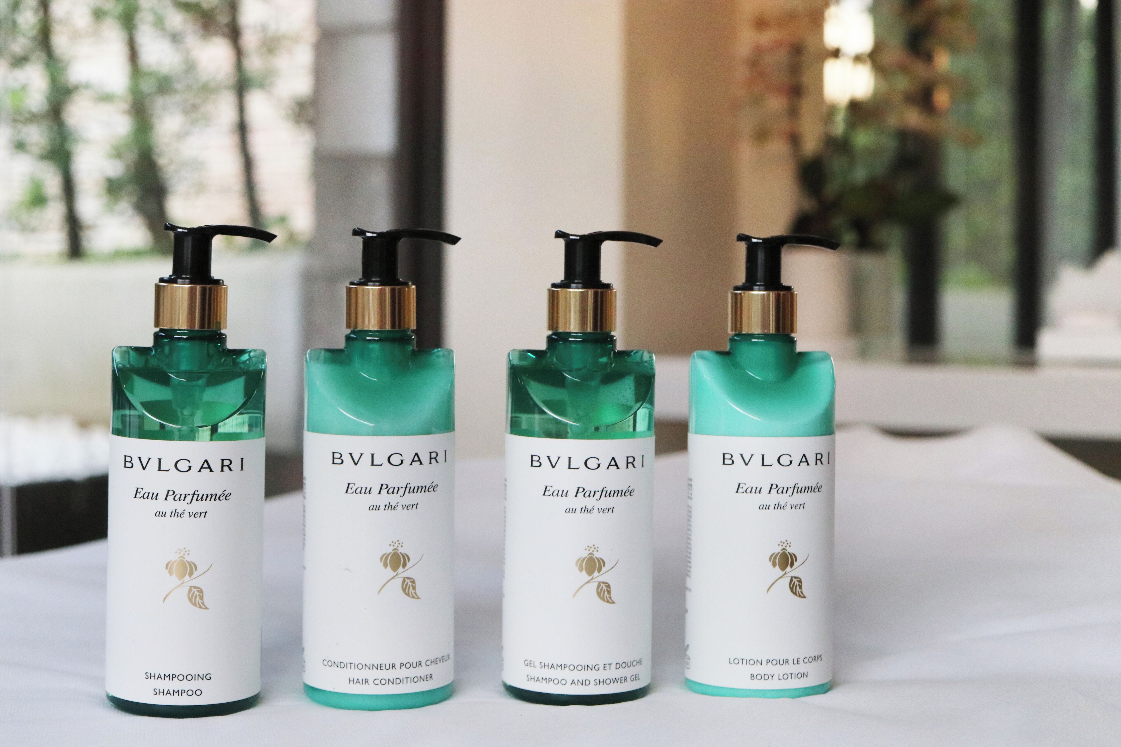 Four bottles of BVLGARI Eau de Parfum on a table.