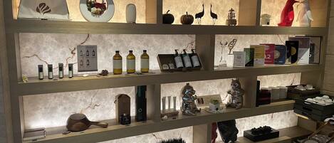 A well-lit display of various items including bottles, figurines, and decorative objects on shelves.