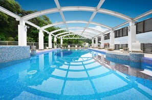 A clear blue pool with a tiled edge, surrounded by white columns and a covered area with seating. - The Gaia Hotel Taipei (Taipei)