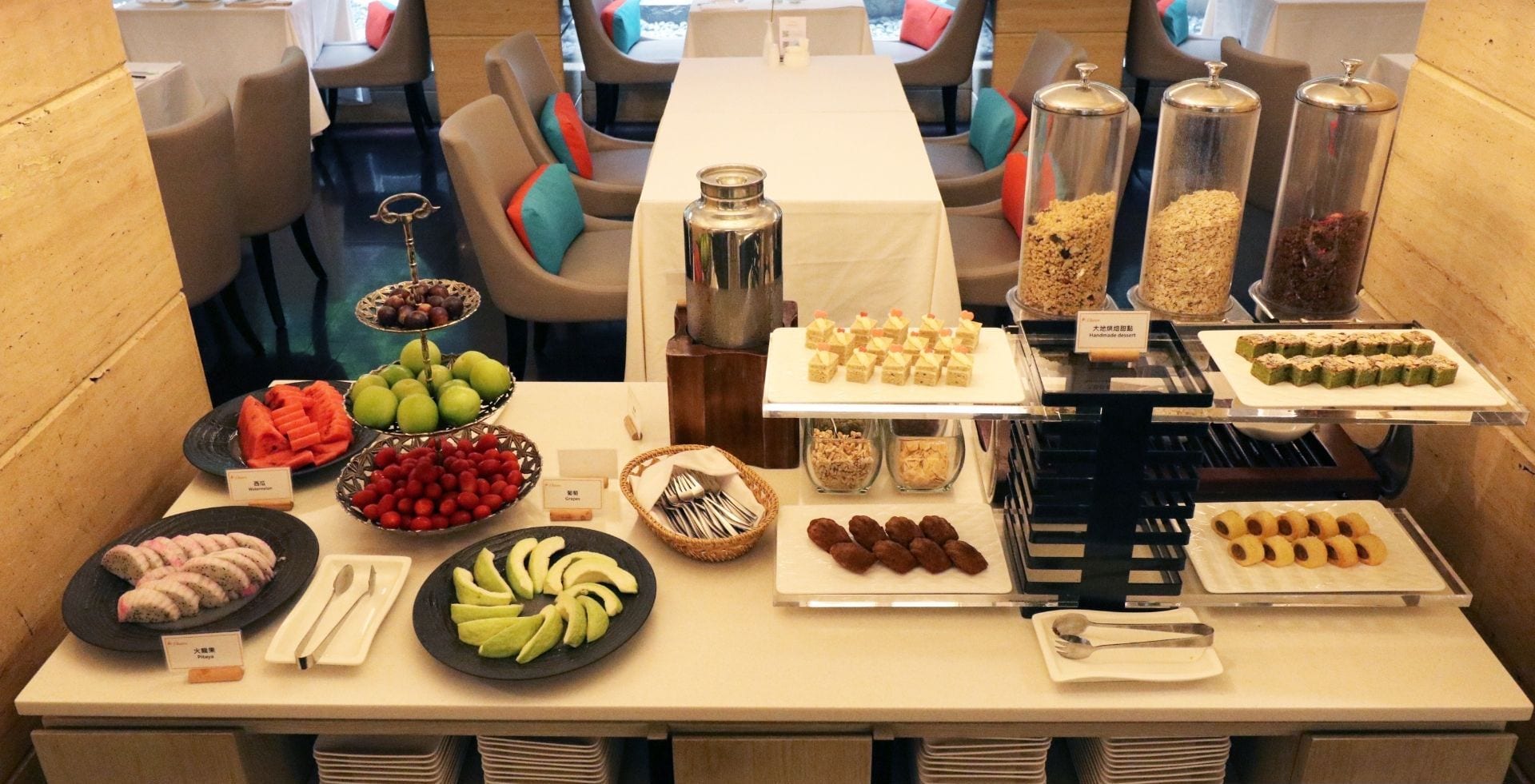 A buffet breakfast setup with various food items and utensils.