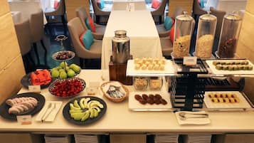 A buffet breakfast setup with various food items and utensils.