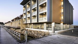 A modern hotel with multiple balconies, a wooden facade, and a stone retaining wall. - Be. Fremantle (Fremantle)