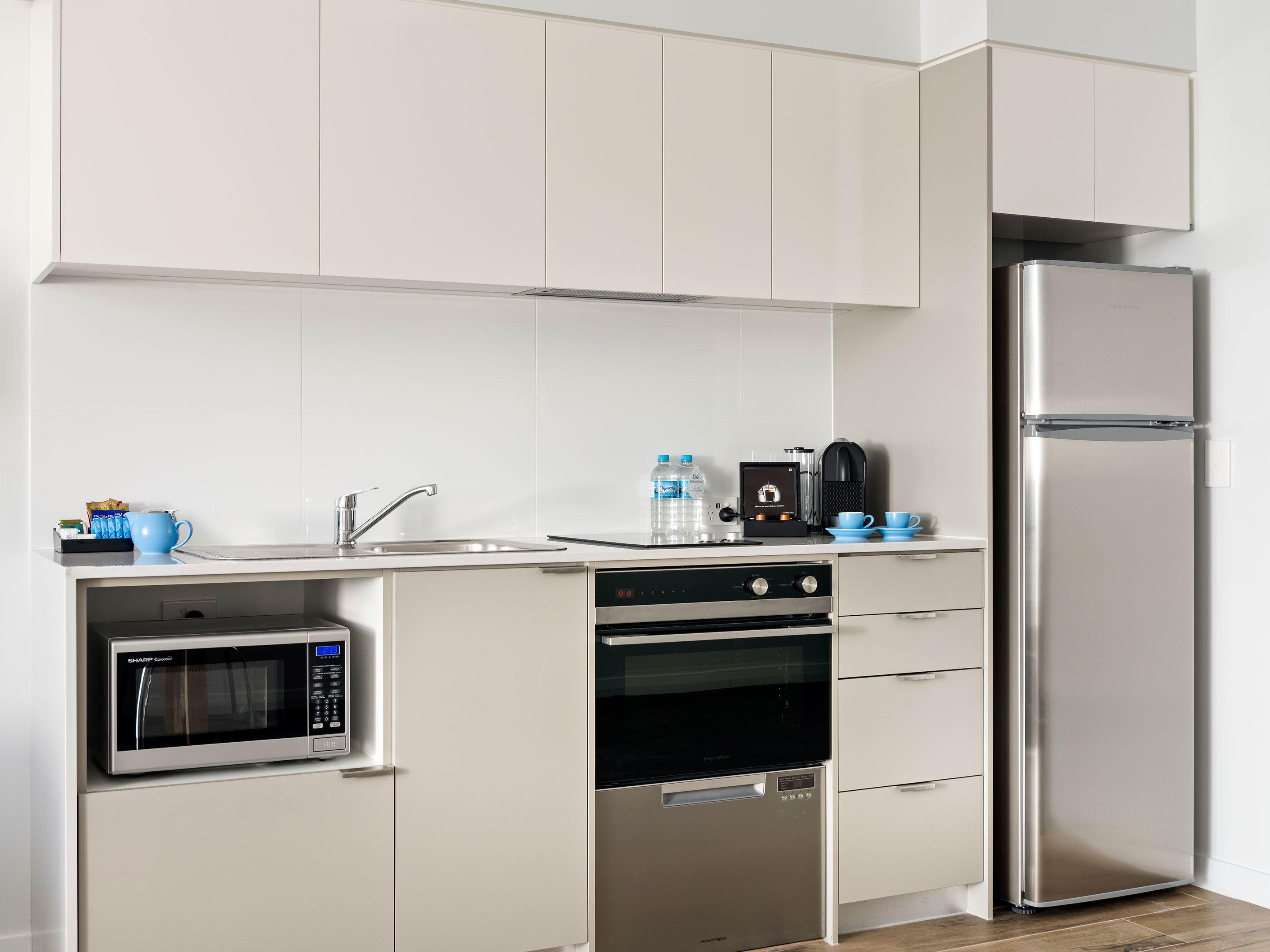 A modern kitchen with a built-in microwave, oven, and refrigerator.