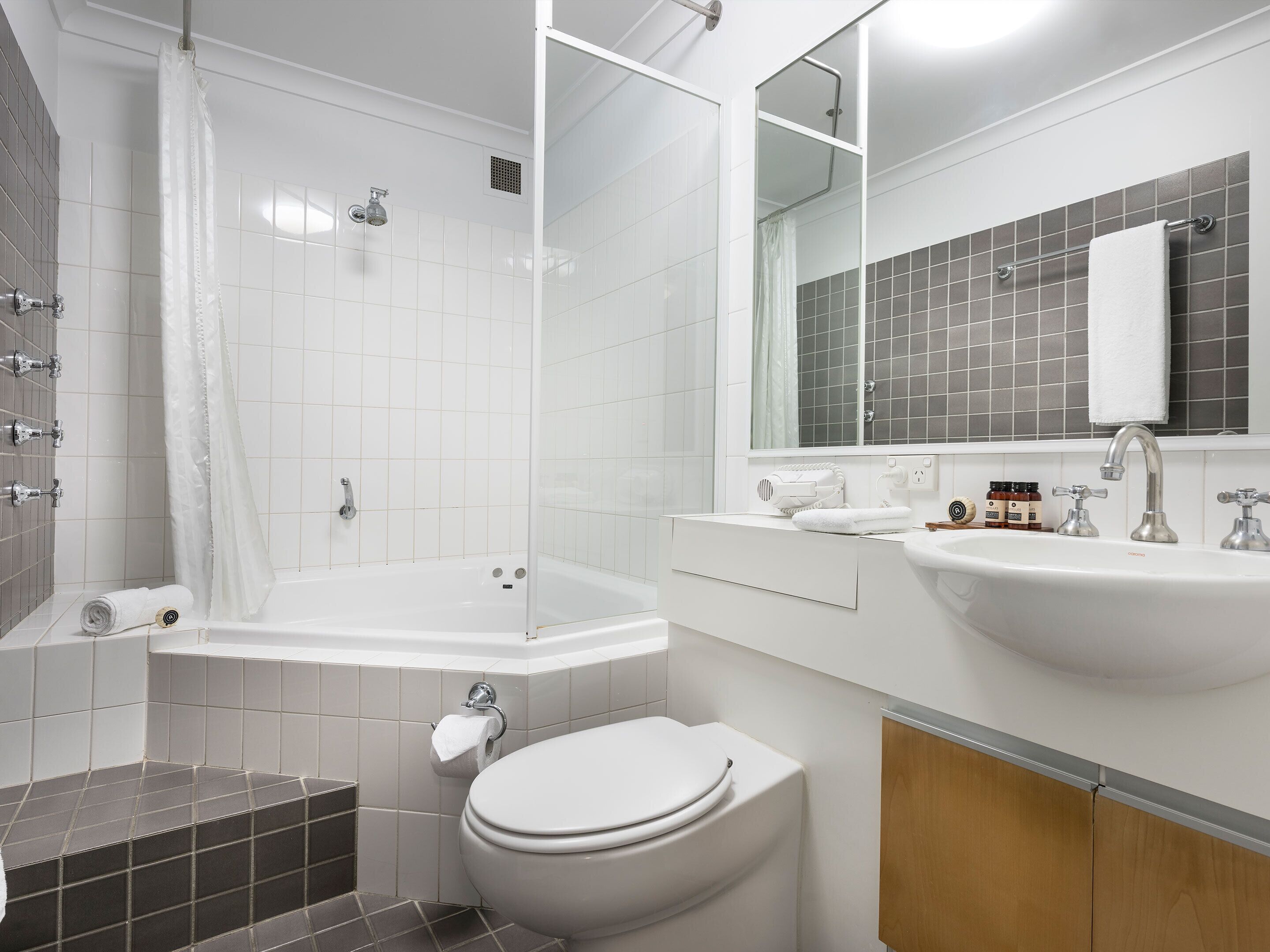 Une salle de bain moderne équipée d’une baignoire, de toilettes et d’un lavabo.