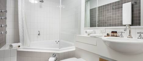 A modern bathroom with a bathtub, toilet, and sink.