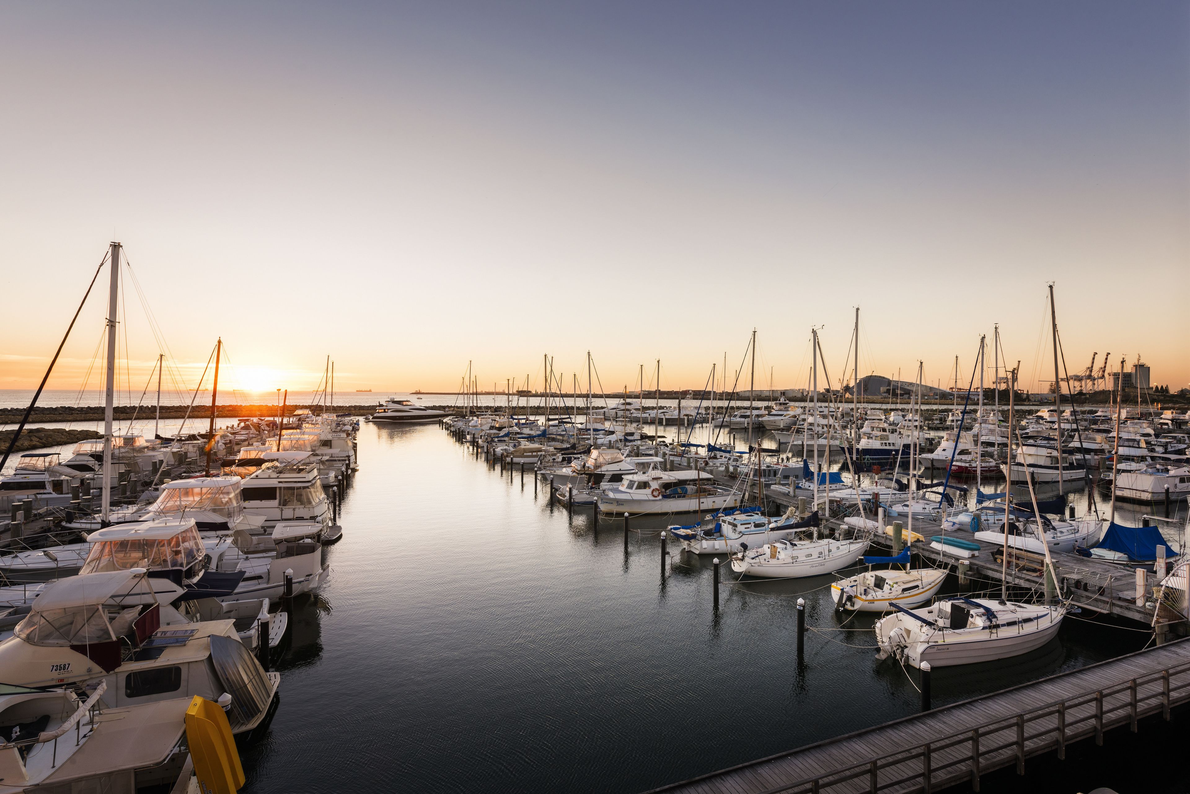 A marina with numerous boats docked at the pier.