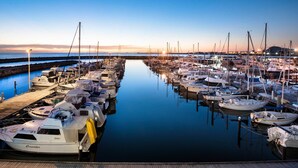 A marina with multiple boats docked, calm water, and a clear sky. - Be. Fremantle (Fremantle)