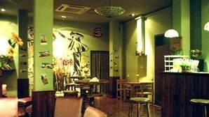 Un interior acogedor con una zona de bar, muebles de madera y decoración en las paredes.
