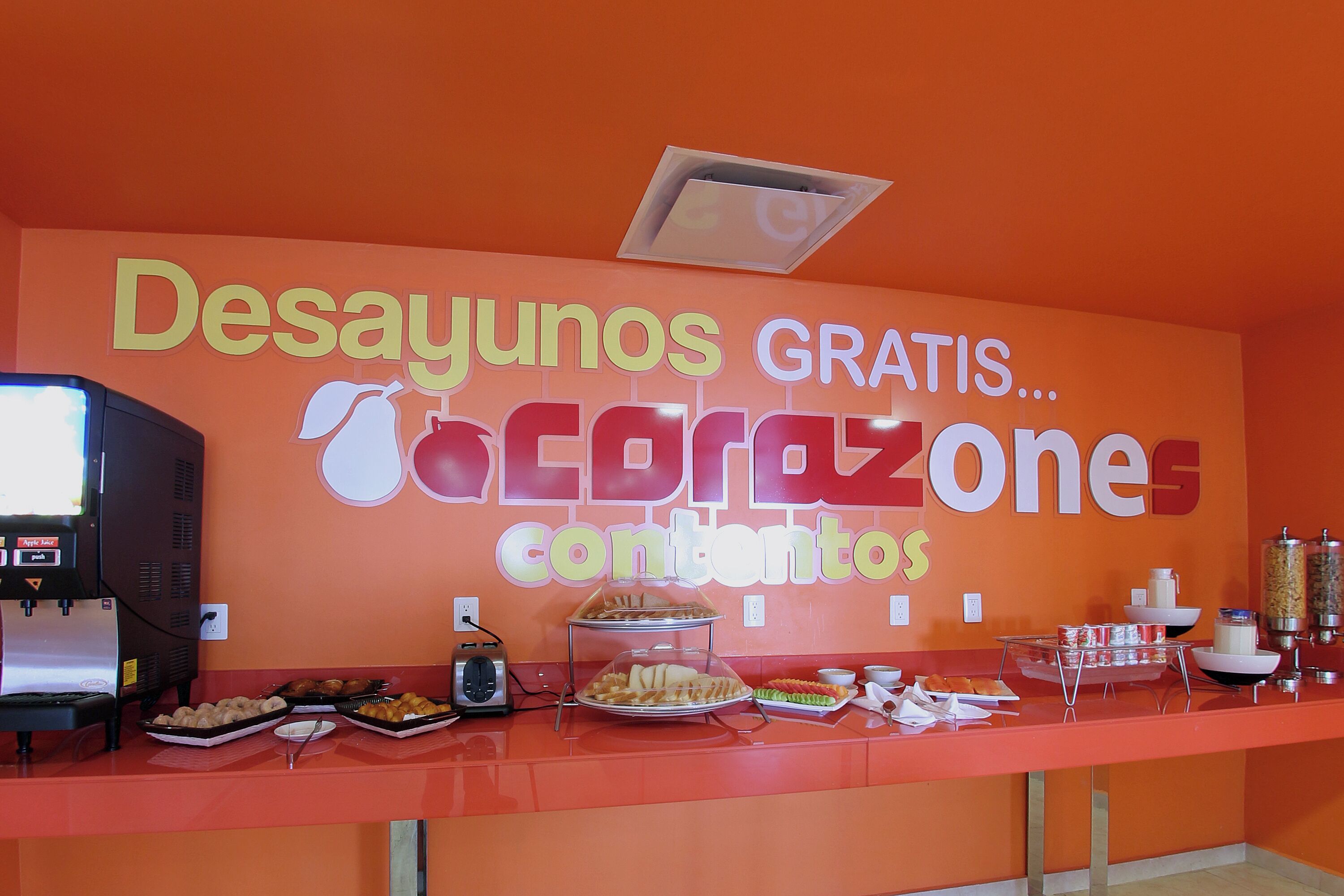Una barra de buffet con un cartel que dice 'Desayunos GRATIS...acrazone contenido'.