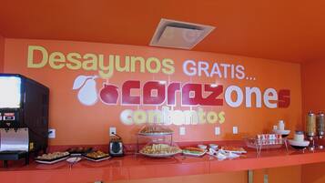 Una barra de buffet con un cartel que dice 'Desayunos GRATIS...acrazone contenido'.