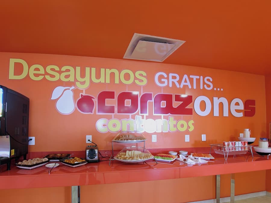 Una barra de buffet con un cartel que dice 'Desayunos GRATIS...acrazone contenido'.
