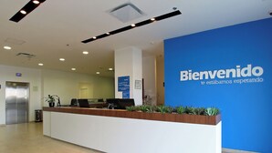 Un comptoir d’accueil avec un mur bleu et une pancarte sur laquelle on peut lire : « Bienvenido, nous vous attendons ».