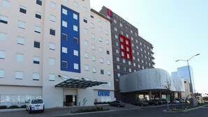 Un hôtel avec une enseigne indiquant qu’il s’agit du seul hôtel, arborant la marque « Fiesta Inn » et une autre enseigne « Dine » signalant la présence d’un espace restauration.