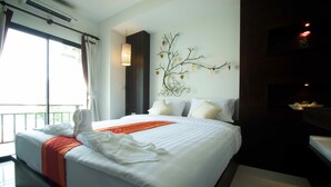 Habitación de hotel con una cama grande, un adorno en la pared y vistas al exterior.