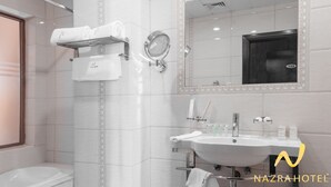 A modern bathroom with a sink, mirror, and towel rack. - Nazra Hotel (Addis Ababa)