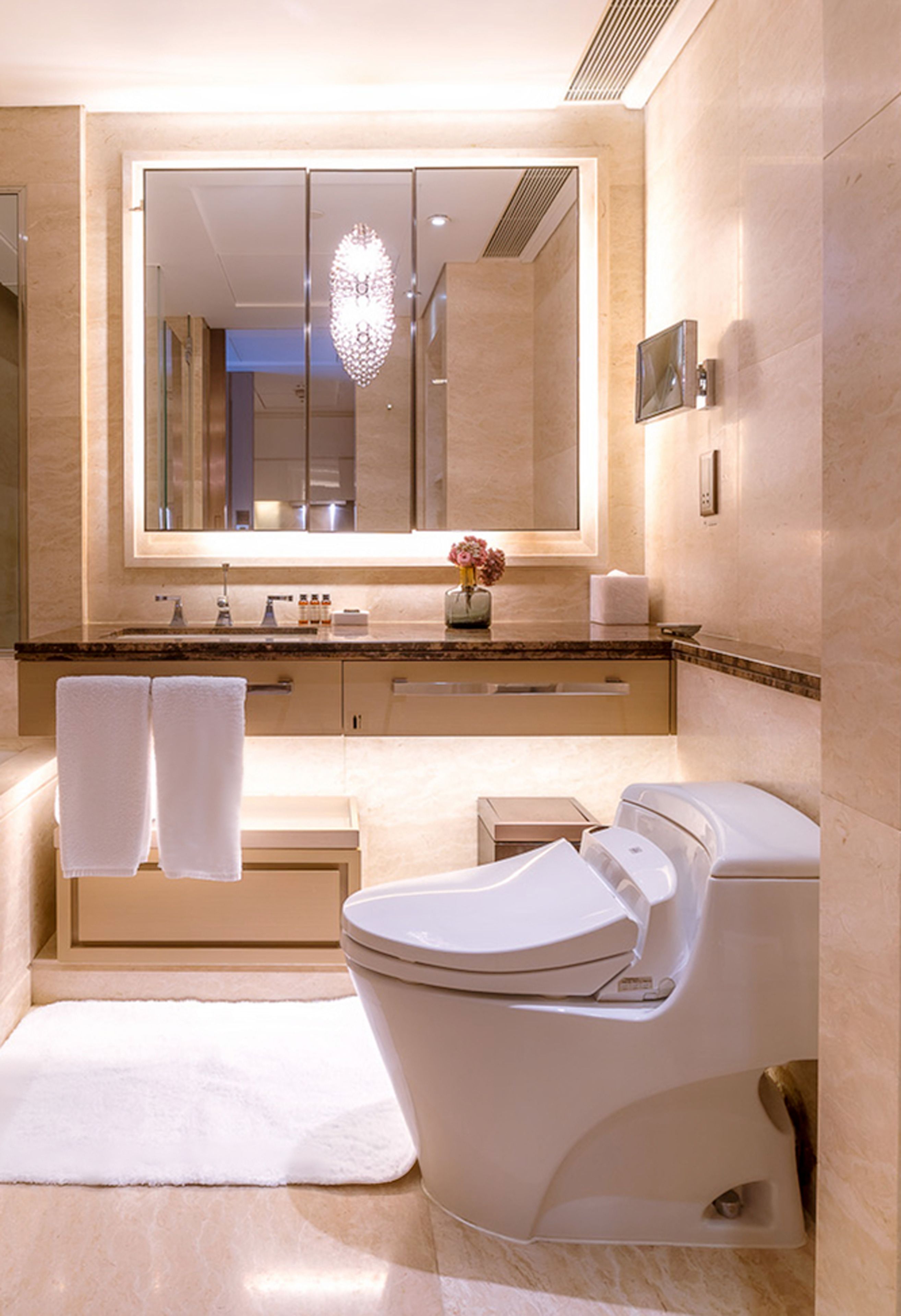 Un baño moderno con un espejo grande, una bañera y un inodoro.