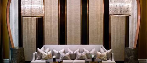 A modern interior with a sofa, two side tables, and decorative panels.