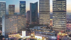 A high-rise building with a modern glass facade, multiple floors, and a prominent signage at the top. - IFC Residence (Shanghai)