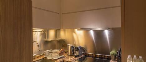 A modern kitchen with a stainless steel range hood, a built-in dishwasher, and a granite countertop.