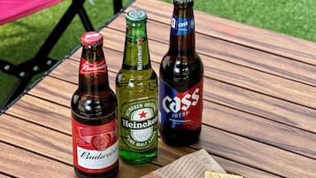 Una mesa con tres botellas de cerveza y un plato de galletas.