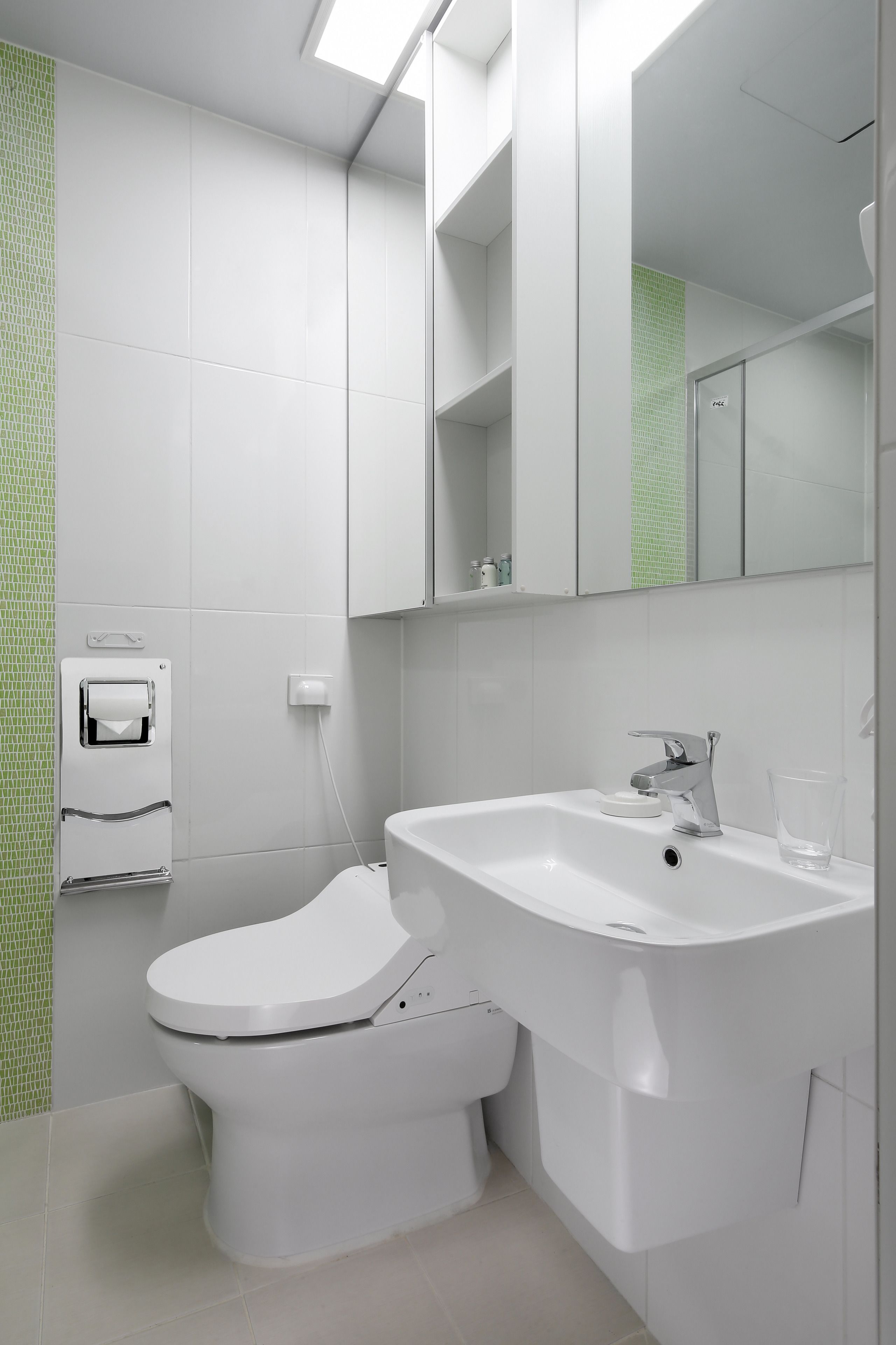 Een moderne badkamer met toilet, wastafel en spiegel.