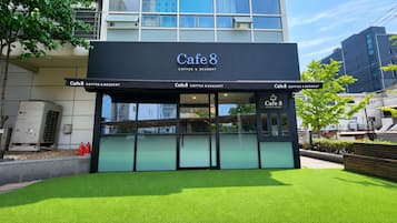 Un edificio con un letrero que dice 'Cafe 8 Coffee & Dessert' y fachada de vidrio.