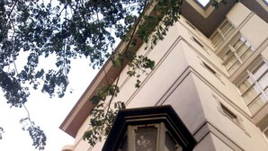 Poste com candeeiro de rua e edifício ao fundo.