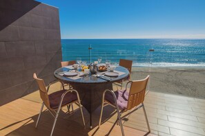 A round table with chairs and a view of the ocean. - Apartamentos Vegasol Playa A.T. (Fuengirola)