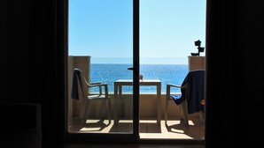 A balcony with a view of the sea, a table, and two chairs. - Apartamentos Vegasol Playa A.T. (Fuengirola)