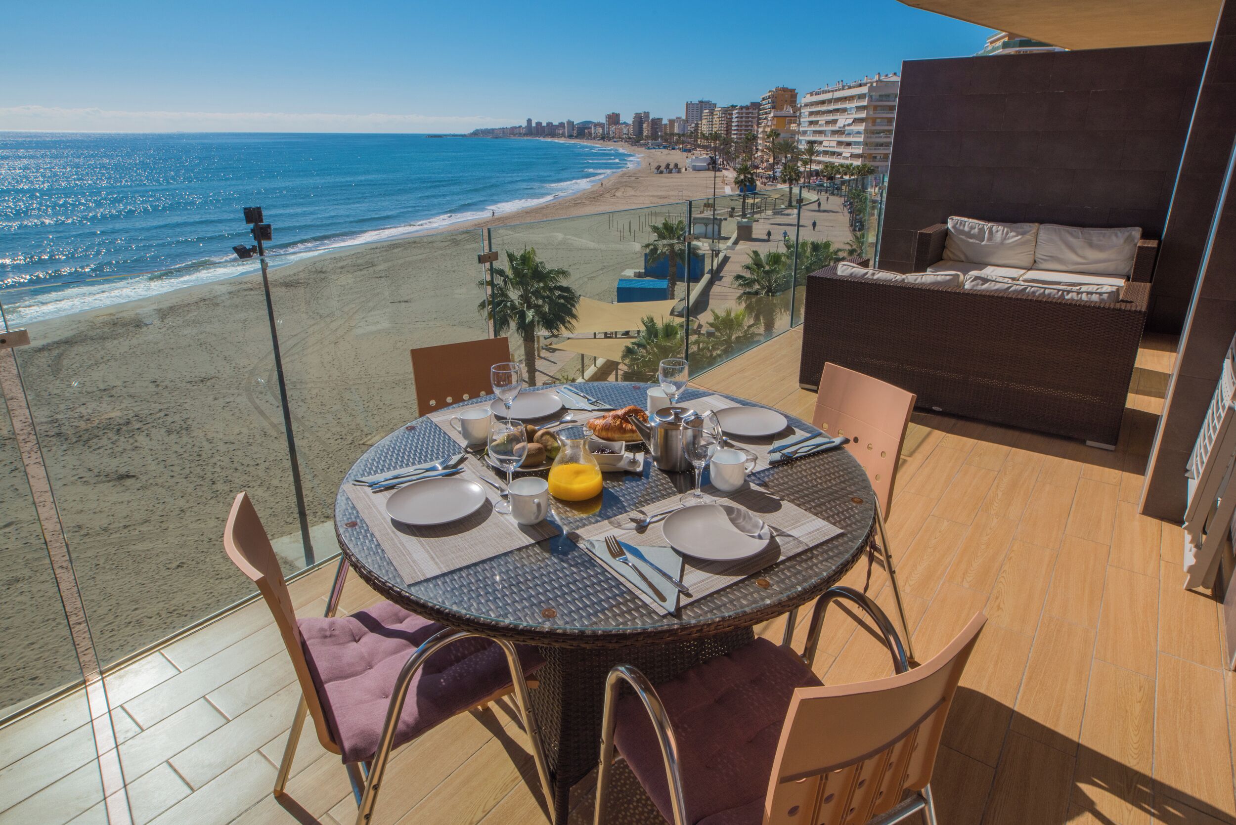 Taula de menjador amb caires i vista a la platja i l'oceà.