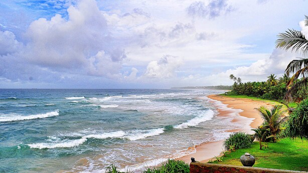 A beach with waves, a clear sky, and greenery. - Club Koggala Village (Koggala)