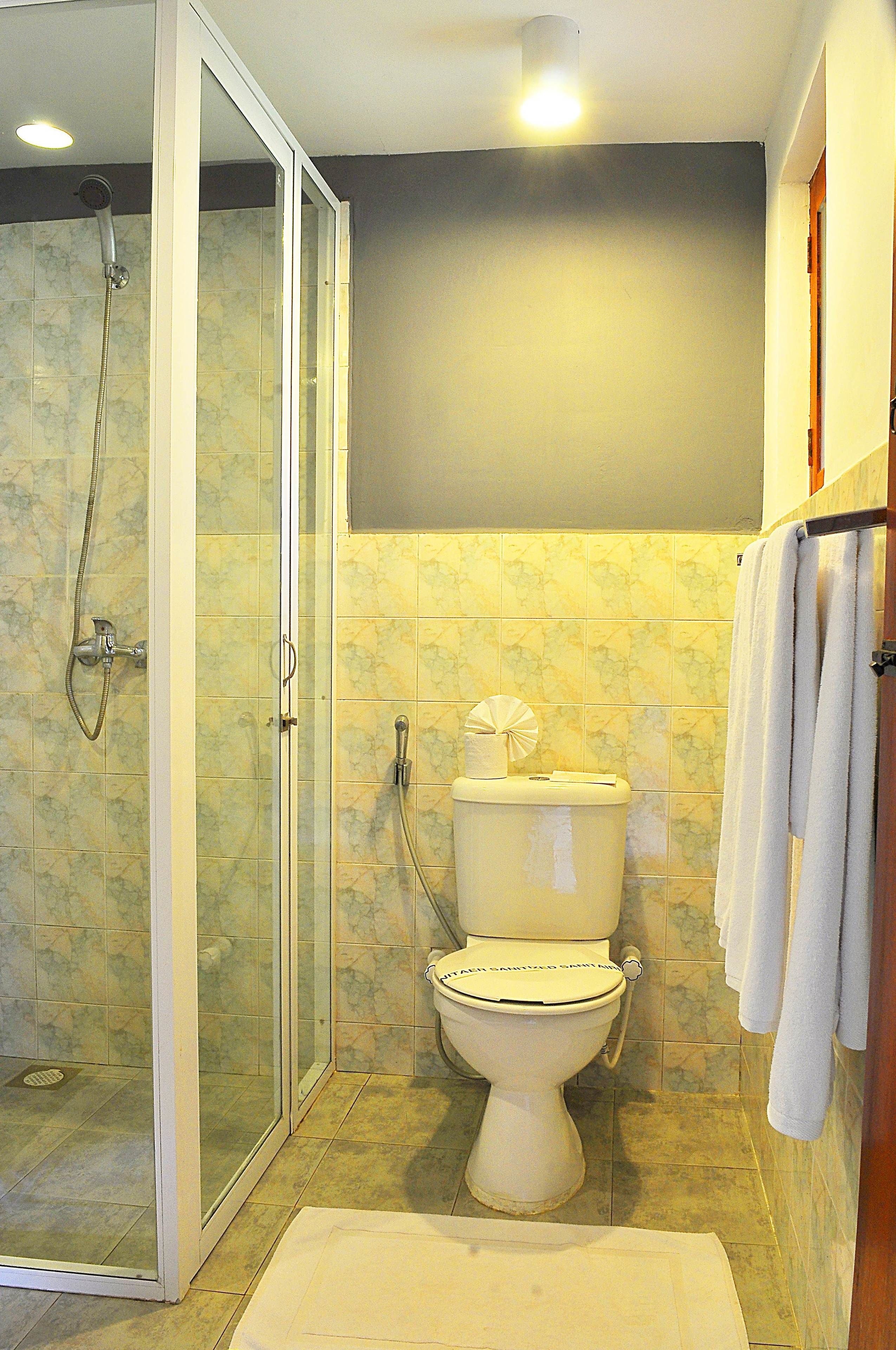 Une salle de bain avec une douche à parois de verre, des toilettes et une baignoire.