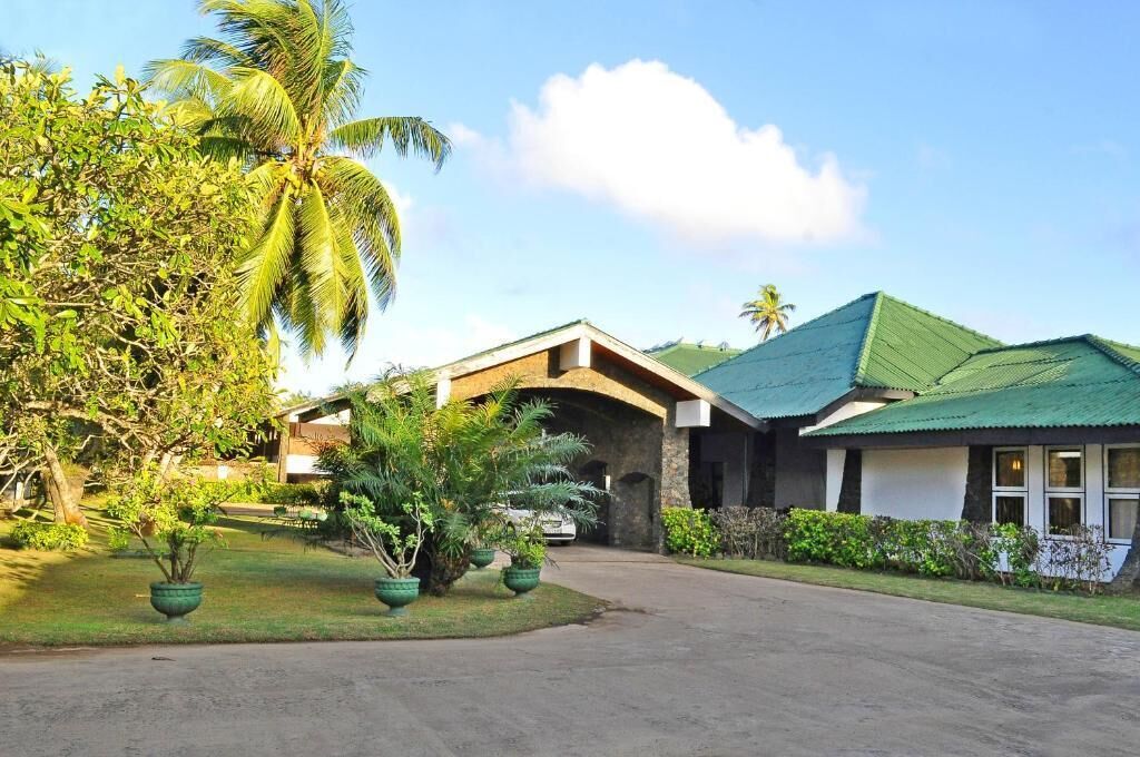 A resort with a stone building, a covered walkway, and lush greenery.