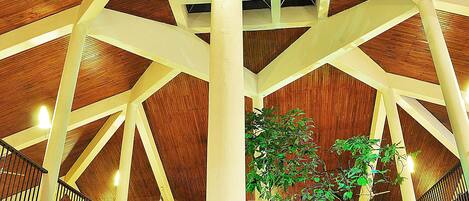 Un amplio atrio con techo de madera alto y una columna blanca en el centro.