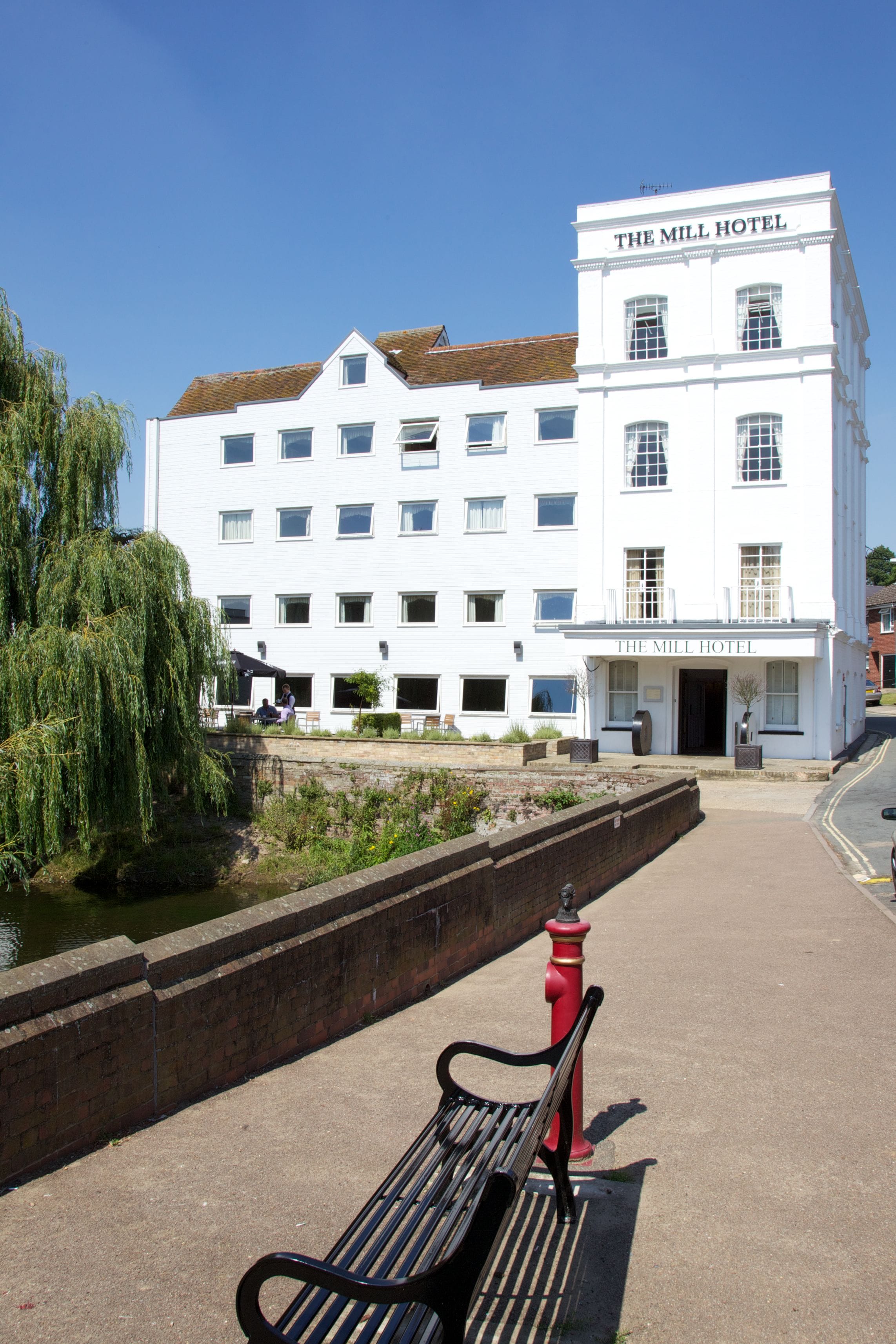 Ein weißes Gebäude mit der Aufschrift "The Mill Hotel" an der Fassade.