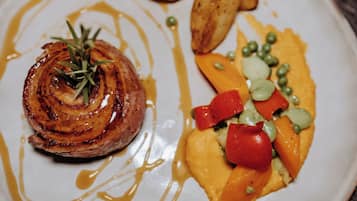 Een bord met een gebakken steak, geroosterde aardappelen en een groentemix.