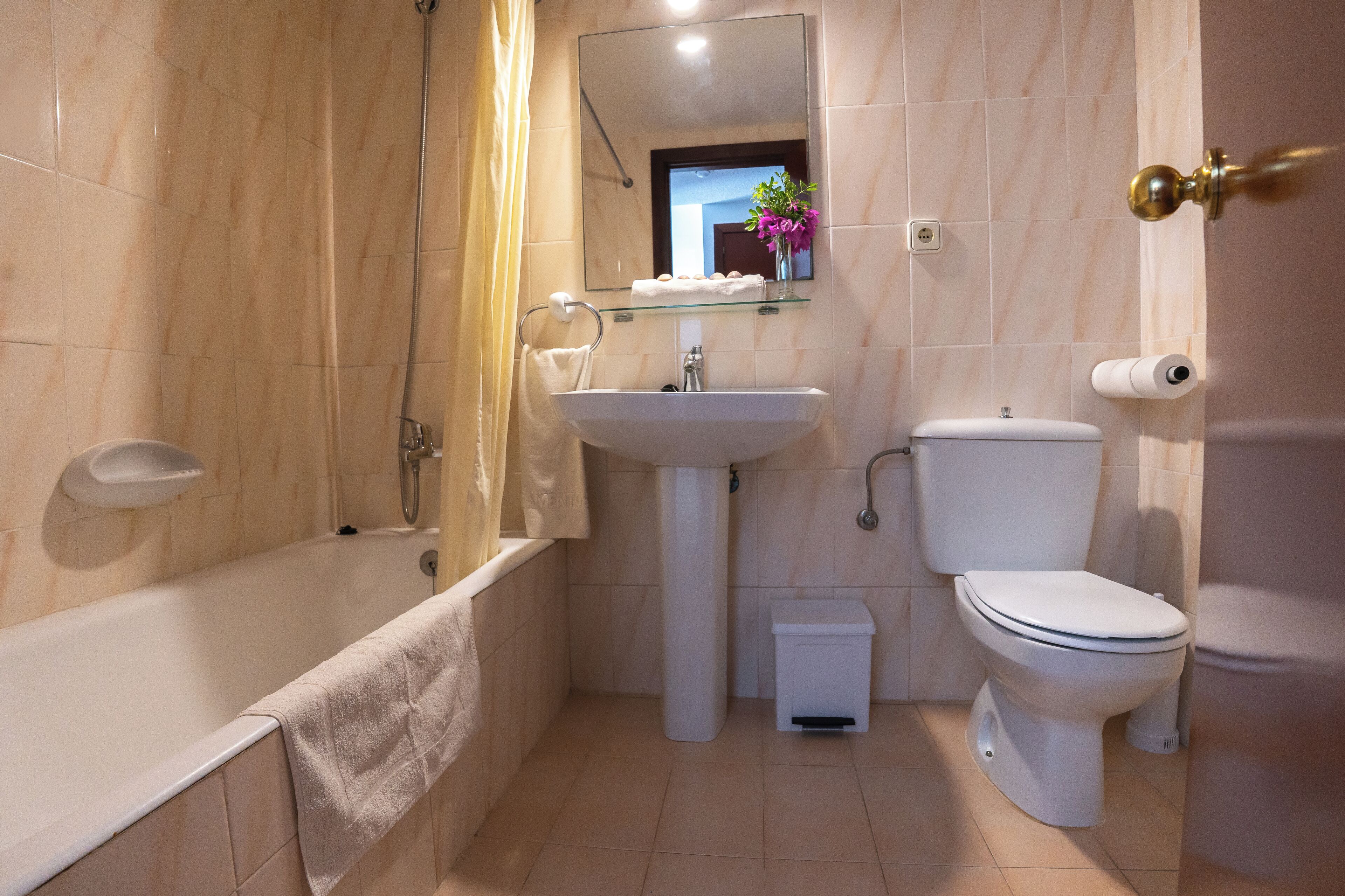 A modern bathroom with a bathtub, a sink, a toilet, and a shower.