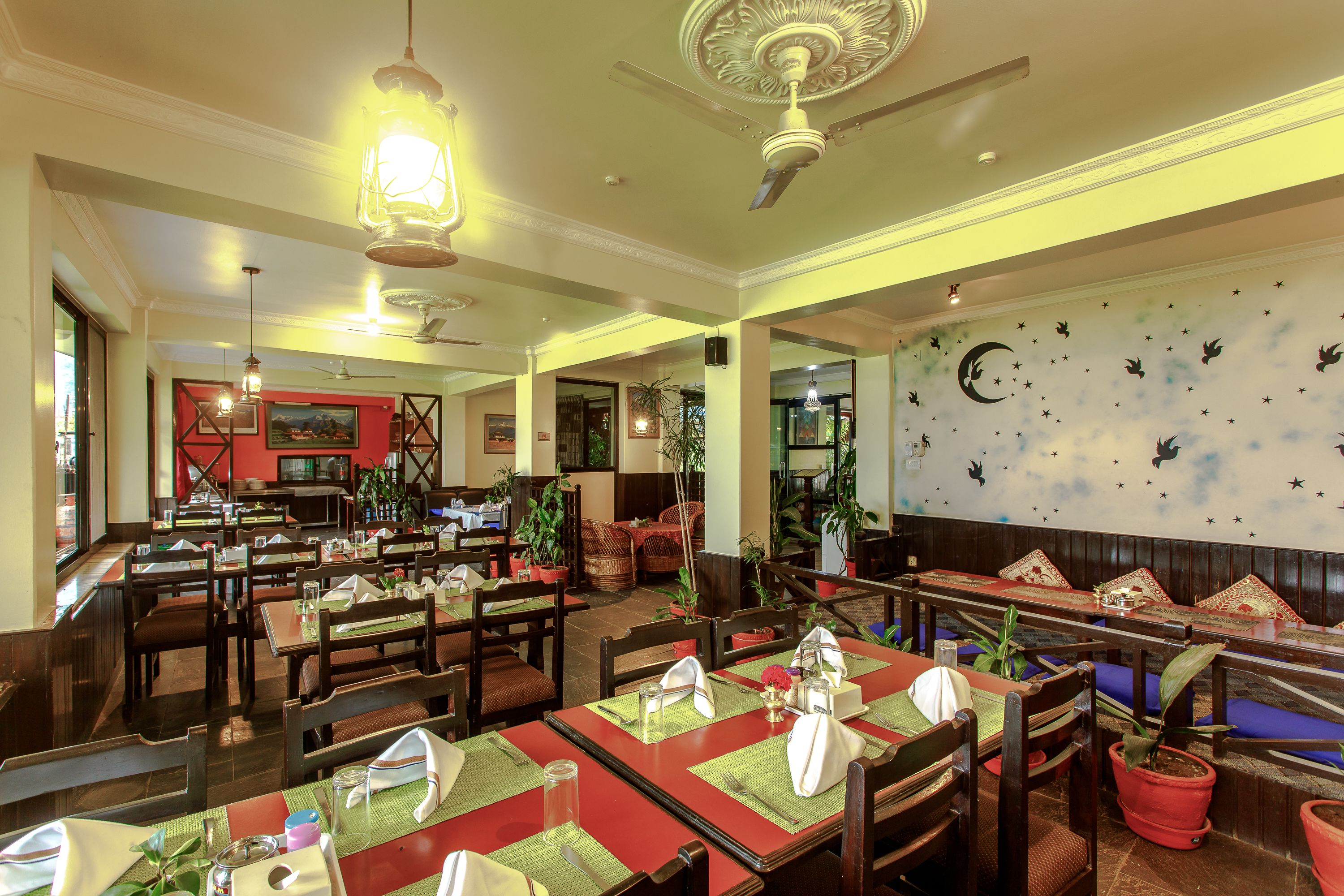 A restaurant with multiple dining tables, chairs, and a ceiling fan.