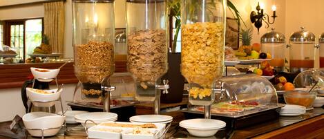 A buffet setup with various food items and containers.