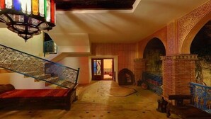 A spacious interior with a staircase, a large window, and a brick wall. - Riad Meknès (Meknes)